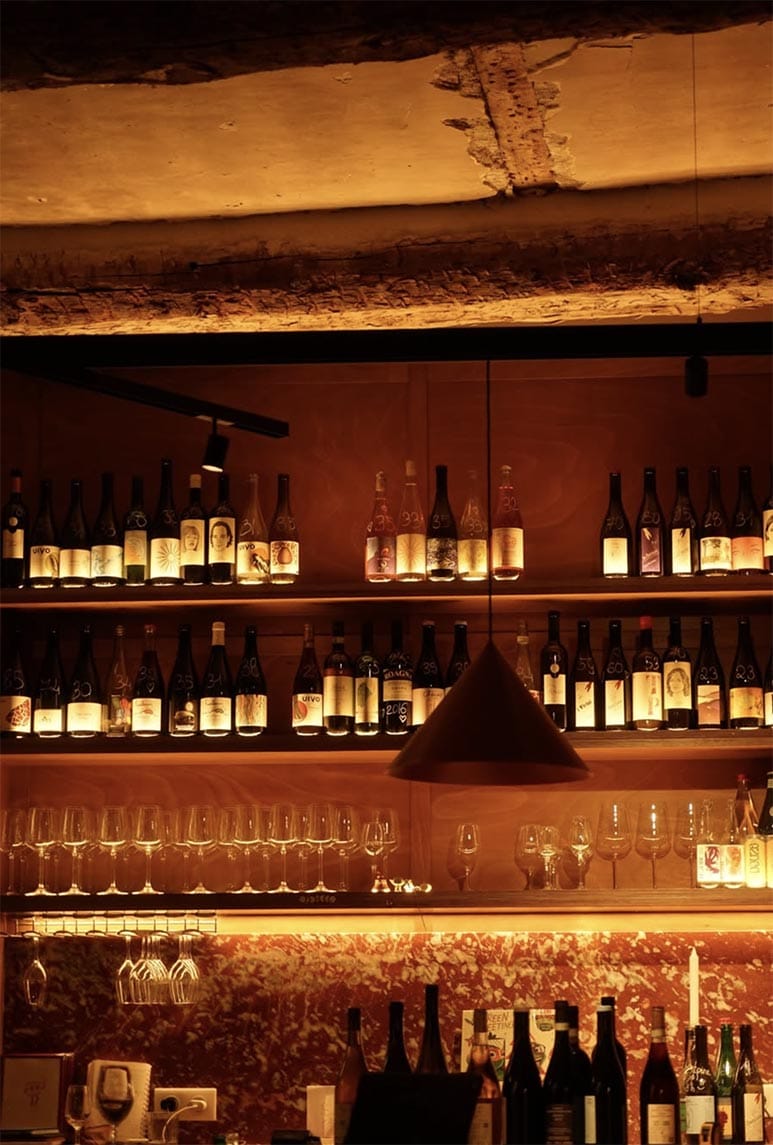 Le bar et ses étagères de bouteilles sous la lumière dorée