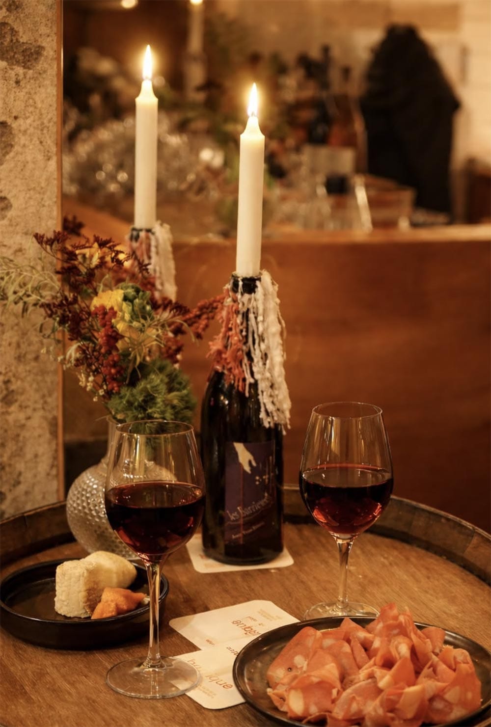 Table dressée : bougies, verres de rouge et charcuterie